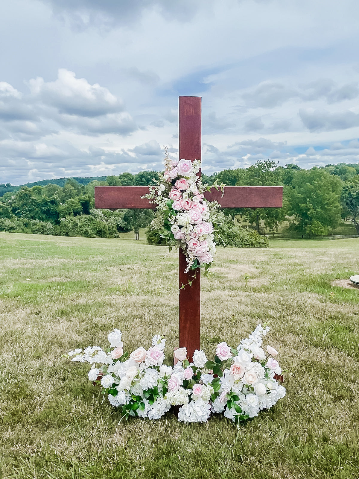Large Wooden Cross Embellished with a Floral Garland.
